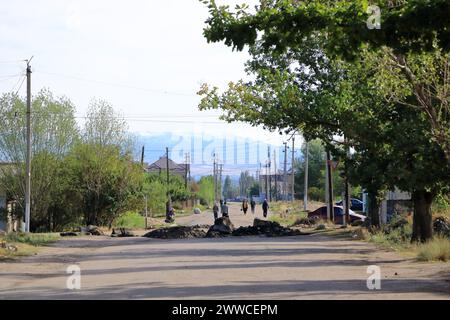 29 de agosto de 2023 - Karakol en Kirguistán: Vista sobre la calle con coches y tiendas en la pequeña ciudad Foto de stock