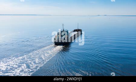 Un gran barco marítimo pasa por el mar en clima soleado y tranquilo, vista aérea Foto de stock