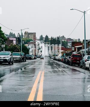 Escena urbana de la calle de la ciudad en el día lluvioso nublado mojado Foto de stock