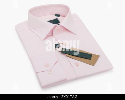 Camisa de hombre doblada rosa con mangas largas y botones sobre un fondo claro Foto de stock
