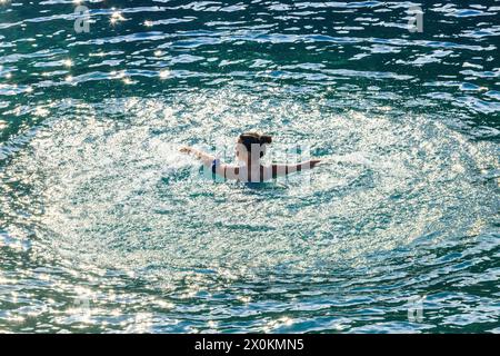 Mujer bañándose en el mar, puerto de Antalya, Turquía. Foto de stock