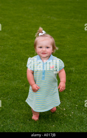 Niña de 14 meses de edad en la hierba en el parque Foto de stock