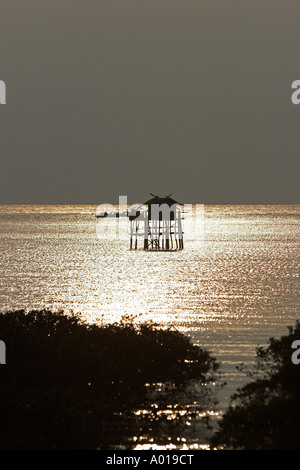 Fisherman's hut sobre pilotes en la Bahía de Halong sunset Isla de Cat Ba Vietnam Foto de stock