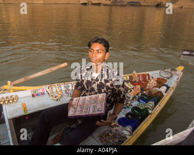 VARANASI en Uttar Pradesh, India Noviembre Hawker tratando de vender sus recuerdos a los visitantes viajar en el río Ganges