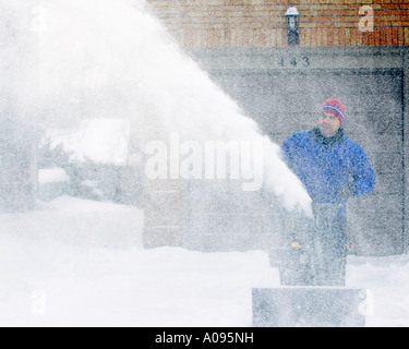 Hombre en ropa de invierno de limpieza con una pala de nieve en las  montañas Fotografía de stock - Alamy