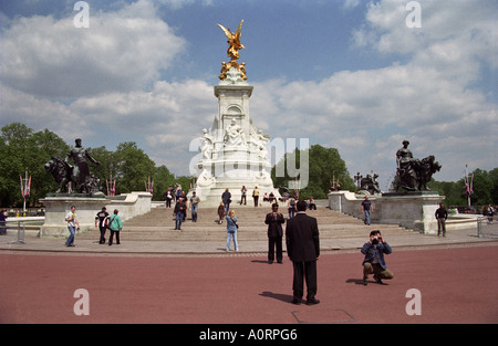 Reino Unido Inglaterra Londres turistas tomando fotografías fuera del Palacio de Buckingham. Victoria Memorial en segundo plano.
