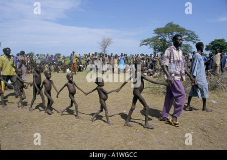 Sudán del sur de agosto de 1998 hambre .AJIEP AYUDA ALIMENTARIA GENERAL TRABAJADORES CON NIÑOS tomados de las manos ALINEANDO PARA ALIMENTOS Foto de stock