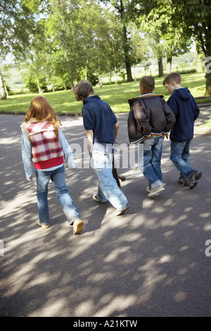 Los niños caminando a lo largo de la carretera