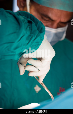 Un cirujano corta en su paciente Foto de stock