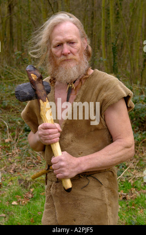 El hombre prehistórico de la Edad de Piedra profesional reenactor con hacha de piedra se hizo en el Museo de la Vida Galesa St Fagans Cardiff Gales UK Foto de stock