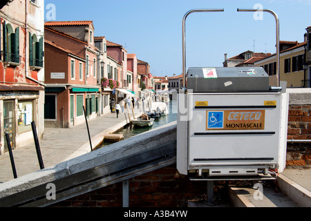 Italia Veneto Venecia en silla de ruedas eléctrica o elevación de la rampa del puente que cruza el canal Rio dei Vetrai Lagoon isla de Murano. Foto de stock