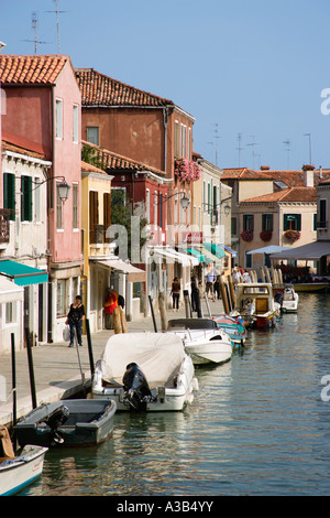Laguna de Venecia Veneto Italia Isla de Murano turistas que caminan en Fondamente dei Vetrai junto a las tiendas y canales con barcos amarrados. Foto de stock