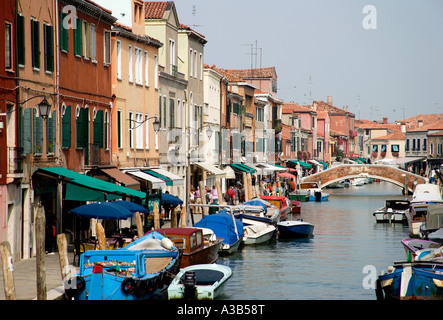 Italia Veneto Venecia Laguna Murano el canal principal de la isla de Fondamente dei Vetrai con barcos amarrados en el muelle y puente sobre canal Foto de stock