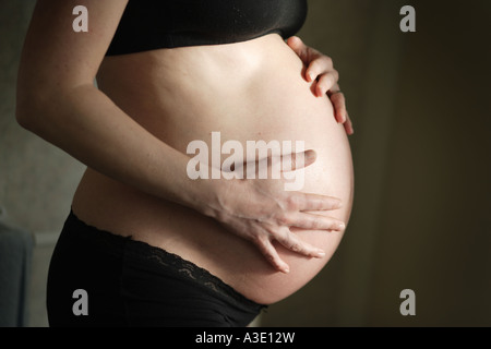 Cerca de una mujer embarazada de 9 meses mostrando su bump Foto de stock