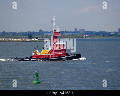 Remolcador de licitación fuego cruzando el puerto de la ciudad de Nueva York Estados Unidos de América Foto de stock