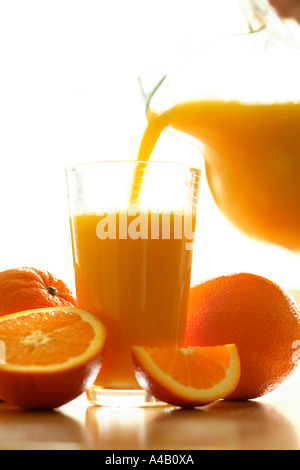 Verter un vaso de jugo de naranja fresco Foto de stock