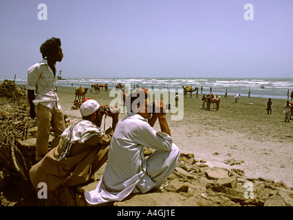 Pakistán Sind Karachi Clifton Beach hombres viendo a la gente a través de unos prismáticos Foto de stock