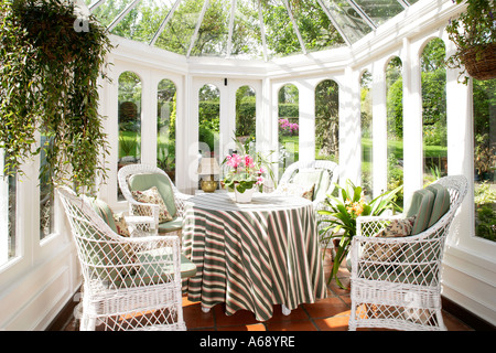 Pequeña sala verde con verde y blanco y cortinas estampadas y silla de  mimbre blanco con cojín verde Fotografía de stock - Alamy