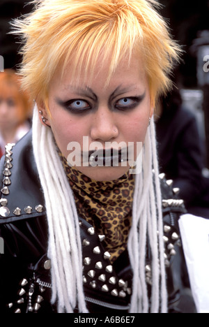 Una niña con ojillos y pelo naranja mira fijamente la cámara durante el 'cosplay', o juego de los disfraces de Harajuku Tokio Foto de stock