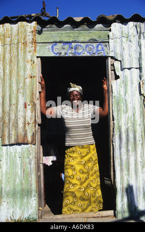 Una dama risas en la puerta de su casa en el municipio de Khayelitsha, Ciudad del Cabo, Sudáfrica Foto de stock