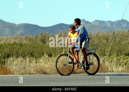 Dos chicos en bicicleta con rueda desinflada ciclismo Western Cape Sudáfrica RSA Foto de stock