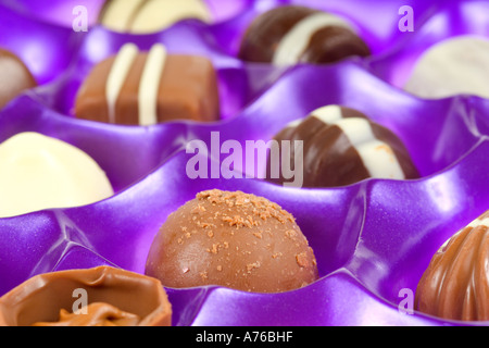 Cerrar la macro de una selección de chocolates en un purple bandeja. Foto de stock