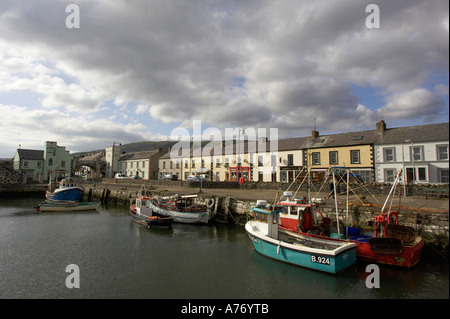Barcos en el puerto en frente de la hilera de casas coloridas Carnlough Village condado de Antrim de Irlanda del Norte Foto de stock