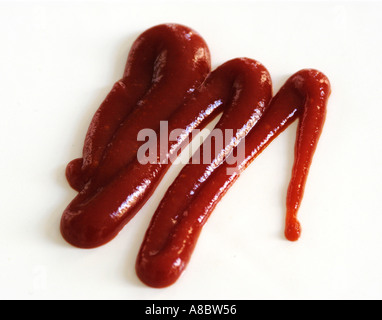 Squiggle de tomate ketchup exprimida de botella squeezy sobre fondo blanco. Foto de stock