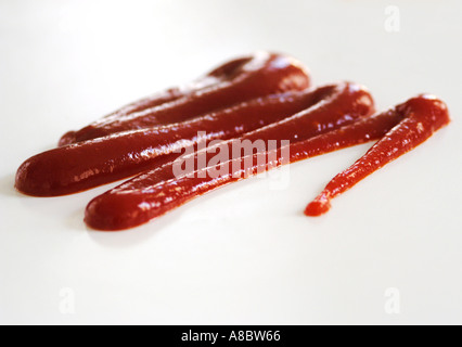 Squiggle de tomate ketchup exprimida de una boquilla en fondo blanco adecuado para convertirse en un recorte Foto de stock