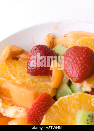Ensalada de frutas en una taza sobre un fondo blanco. Foto de stock
