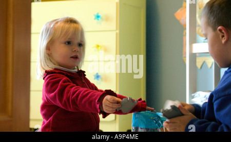 Niños y niñas caucásicos preescolares amigos jugando fútbol americano