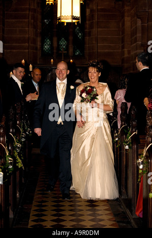 La novia y el novio caminando por el pasillo Foto de stock