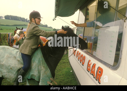 Los niños s poney club gymkhana Buckinghamshire una niña sobre su caballo en el vagón alimentos HOMERO SYKES