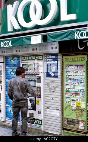 Nov 2, 2004 - Hombre compra un paquete de cigarrillos de una máquina expendedora en Shibuya de Tokio. Foto de stock