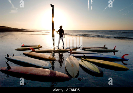 Surfboarder en Brighton Beach con una colección de placas antiguas vintage Foto de stock