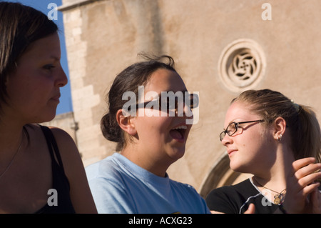 Sólo para uso editorial ningún modelo de liberación tres chicas adolescentes riéndose y aplaudiendo en la Plaza 9 de abril en Taormina. Foto de stock