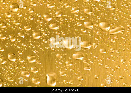 Metal oro con gotas de agua en Foto de stock