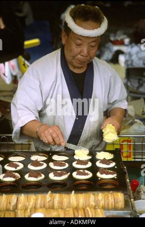 Un hombre hace Azuki (frijol rojo) pasteles durante un matsuri en Tokio, Japón Foto de stock