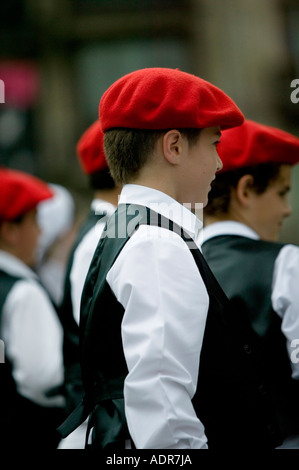 Los muchachos vestidos de rojo boina la txapela la actuación de danzas vascas Plaza Arriaga Bilbao, España Fotografía de stock -