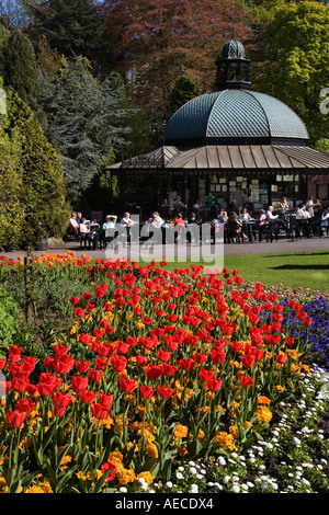Personas sentadas en un café disfrutando de Sol de primavera en Jardines del Valle de Harrogate North Yorkshire, Inglaterra