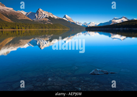 Todavía perfectamente las cristalinas aguas del lago Maligne, el Parque Nacional de Jasper, Canadá Foto de stock