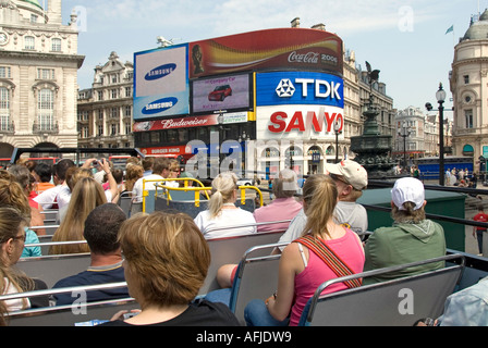 Londres top deck a bordo del autobús turístico descapotable con turistas vistas hacia Piccadilly Circus Eros y acaparamiento de publicidad Foto de stock