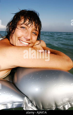 Belleza femenina francesa flotando sobre una plata lilo Foto de stock