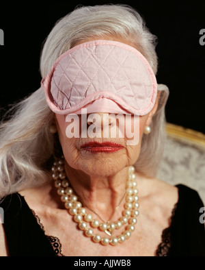 Los funcionarios superiores de adultos mujer vistiendo máscara de ojo rosado