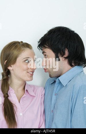 Pareja joven haciendo caras tontas el uno al otro, la cabeza y los hombros, Retrato