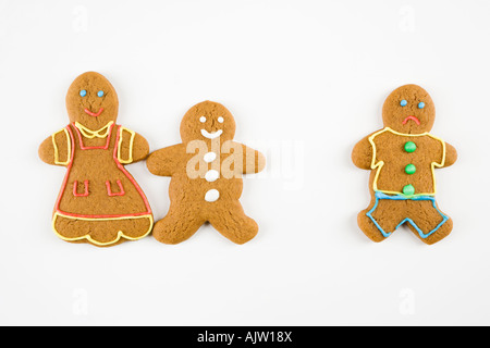 Fruncir el ceño gingerbread cookie permanente masculina separada de feliz gingerbread cookies manos Foto de stock