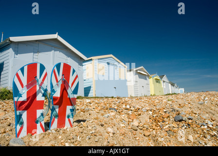 Par de flip flops en Pebble Beach con cabañas de playa en St Leonards antecedentes sobre mar Hastings Sussex England GB Foto de stock