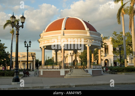 La noche, la luz del sol incide sobre la delicada decoración y tejado rojo del quiosco, el Parque José Martí, Cienfuegos, Cuba Foto de stock