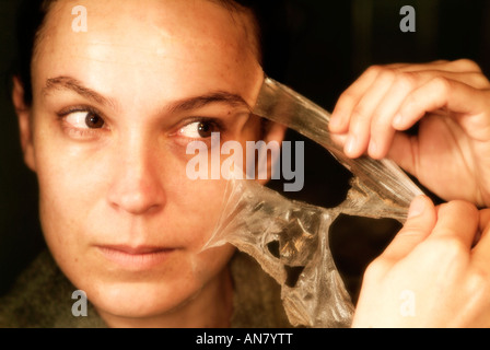 Mujer eliminando de sí una máscara de limpieza facial Foto de stock