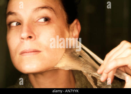 Mujer eliminando de sí una máscara de limpieza facial Foto de stock